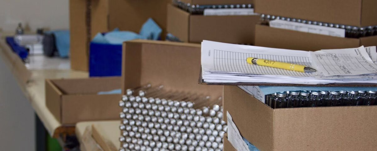 Components and production documentation staged at a manufacturing workbench for a build-to-print assembly project at General Assembly & Manufacturing Corp.