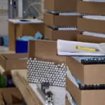 Components and production documentation staged at a manufacturing workbench for a build-to-print assembly project at General Assembly & Manufacturing Corp.